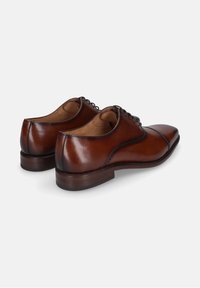 Scarpe eleganti in pelle marrone con punta affusolata, texture liscia e dettagli di cucitura sottili. Presentano un tacco basso impilato e un design con lacci.
