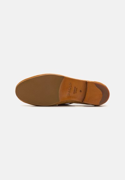 Suola di scarpa in pelle marrone con texture scanalata, caratterizzata da un marchio impresso e informazioni sulla taglia. La suola ha una finitura liscia vicino al tallone.