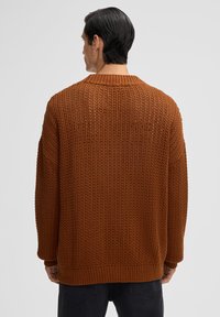 Maglione marrone a maglia con una vestibilità morbida, caratterizzato da un motivo testurizzato, colletto e orlo a coste e spalle scese.