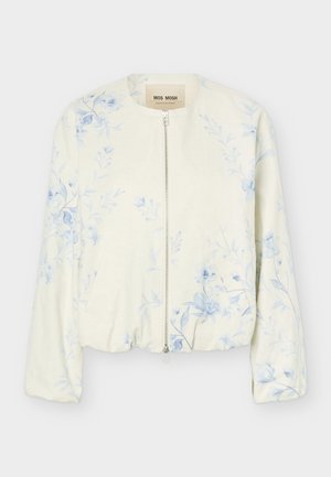 Veste crème à fermeture éclair avec motif floral bleu clair, col rond et manches longues, étiquetée "Mos Mosh."