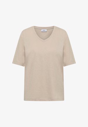 T-shirt beige à manches courtes avec col en V, portant une étiquette à l'intérieur du col indiquant "CECIL", présenté sur un fond blanc.