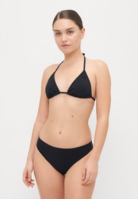 Black bikini set featuring a triangular top with thin straps and a simple banded bottom. Smooth texture and minimal design.