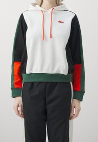 Felpa con cappuccio in bianco, verde, nero e rosso. Caratterizzata da lacci, polsini elasticizzati e un logo ricamato sul petto. Tessuto morbido.