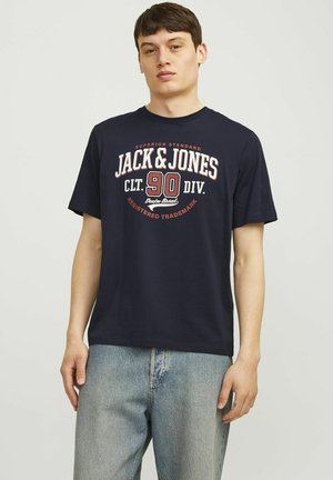 Navy blue cotton t-shirt with short sleeves and a crew neckline. Graphic print on the front includes text and a circular design in red and white.