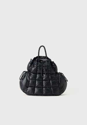 Black quilted nylon handbag with gathered drawstring top, side pockets, and short braided handles against a neutral background.