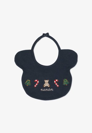 Bavoir en coton bleu marine avec des coins arrondis, comportant des motifs brodés d'un ours en peluche, d'arbres de Noël, de cannes en sucre, et du texte "nanán."
