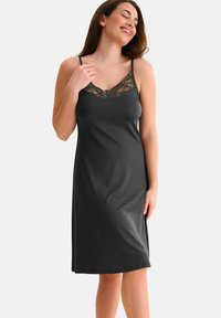 Nuisette gris foncé avec bordure en dentelle au niveau du décolleté, bretelles spaghetti réglables et texture de tissu lisse. Longueur jusqu'aux genoux.