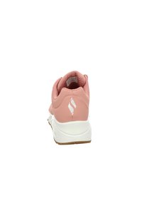 Helle rosa Sportschuhe mit gepolsterter Ferse, strukturiertem Obermaterial und weißer Sohle mit Logo-Akzent. Minimalistisches Design, geeignet für Sport.