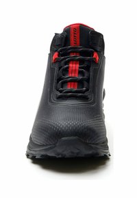 Scarpa da corsa nera con superficie testurizzata, dettagli rossi e strisce. Presenta lacci e una suola in gomma robusta per una buona aderenza.