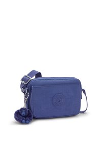 Borsa a tracolla viola in tessuto con finitura testurizzata, patch con logo e ciondolo peloso attaccato. Include una tracolla removibile e chiusura con zip.