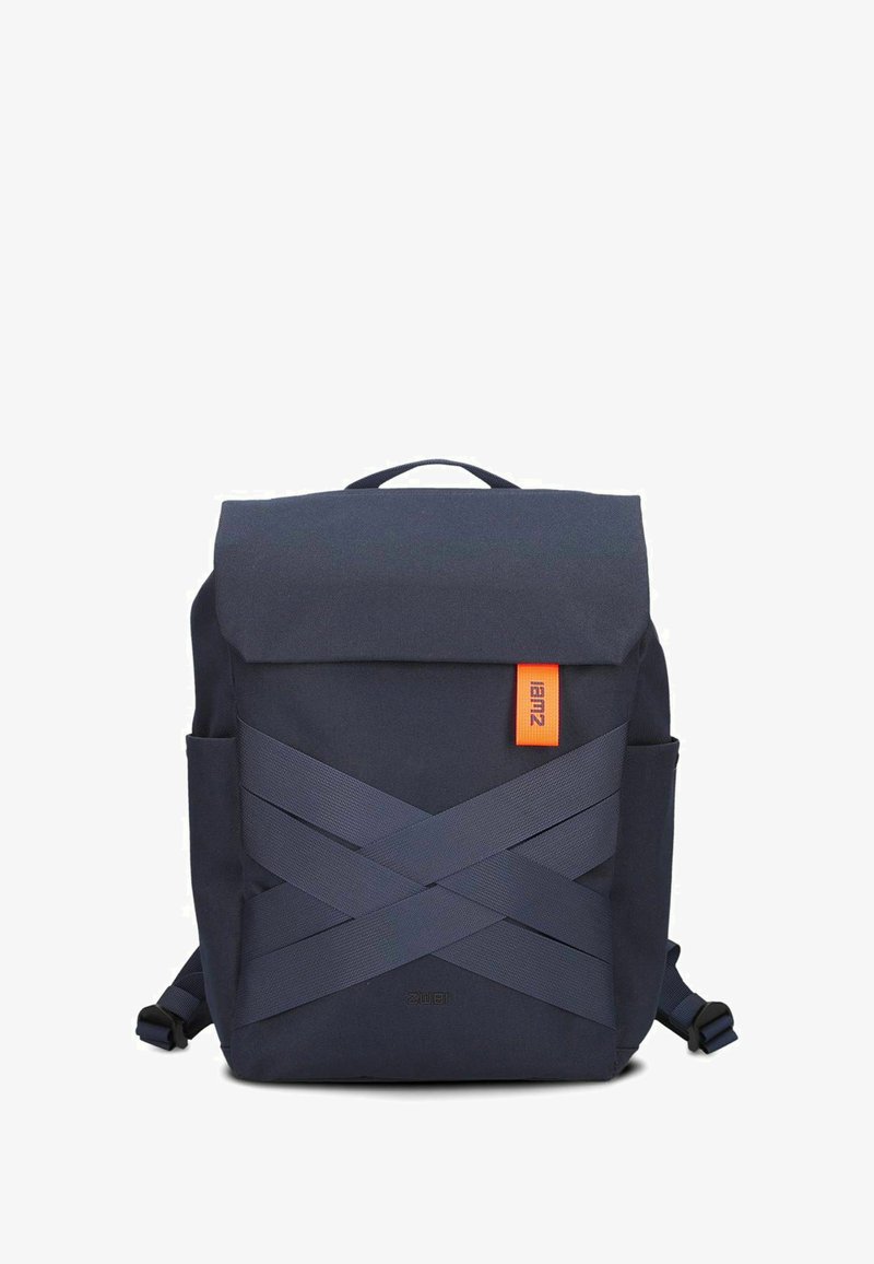 Sac à dos bleu marine avec un dessus repliable, doté de sangles croisées, d'une étiquette orange, de poches latérales et d'une texture de tissu lisse et durable.