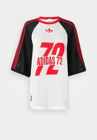 Īsām piedurkņu sporta krekls no sietiņa ar melnām piedurknēm, sarkaniem svītrām, sarkanu "72 ADIDAS" tekstu un sarkano Adidas logo uz baltas priekšējās paneļa.
