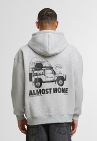 Gray cotton hoodie with a large black graphic of a vehicle and text "ALMOST HOME" on the back. Features a drawstring hood and ribbed cuffs.