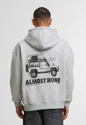 Gray cotton hoodie with a large black graphic of a vehicle and text "ALMOST HOME" on the back. Features a drawstring hood and ribbed cuffs.