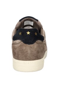 Braune Wildleder-Sneaker mit einer schwarzen Wildleder-Häkelblende und goldenen Sternen, cremefarbener Gummisohle mit Struktur und gepolstertem Kragen für zusätzlichen Komfort.