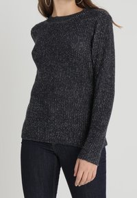 Dunkelgrauer Strickpullover mit Rundhalsausschnitt, langen Ärmeln und einem strukturierten Muster. Das Material scheint weich und leicht dehnbar zu sein.