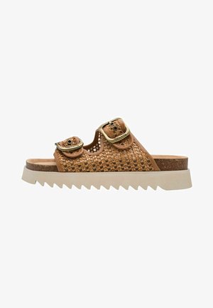 Brown woven slide sandals with two gold buckles, wide slip-on design, cork footbed, and beige serrated rubber outsole.