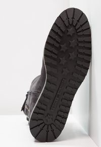 Stivale in suede nero con suola in gomma testurizzata, dotato di battistrada a motivo stelle e zip laterale per la chiusura. Logo del marchio visibile sulla suola.