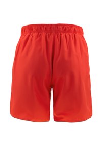 Pantalones cortos deportivos rojos hechos de un tejido ligero, con una cinturilla elástica y una superficie lisa y texturizada. Sin bolsillos ni adornos.