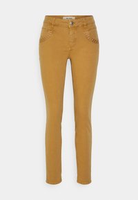 Hořčicově žluté úzké džíny s prošitím na předních kapsách a knoflíkovým zapínáním v pase. Hladký denimový texture.