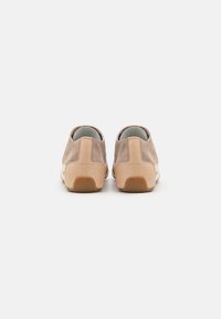 Wildlederschuhe in Tan mit einer strukturierten Gummisohle. Die Rückansicht zeigt eine glatte Ferse und ein minimalistisches Design.