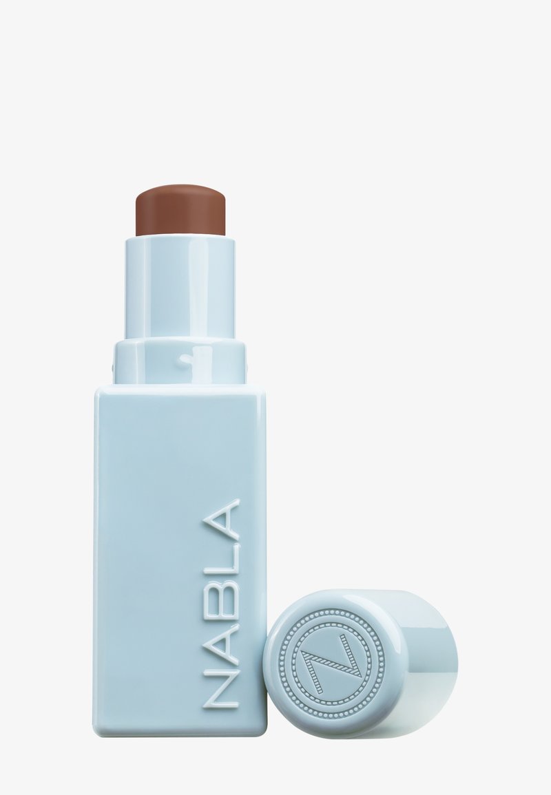 NABLA cream stick in light blue packaging, with a brown stick applicator. Features a circular lid with embossed logo detailing.