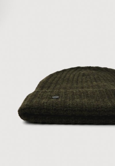 Zaļš adīts beanie cepure ar saliektu malā, ar ribotu faktūru un mazu melnu logotipu sānos. Mīksts vilnas maisījuma materiāls.