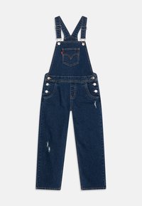 Džínové overal v tmavě modré barvě, s nastavitelnými popruhy, velkými kapsami, stříbrnými detaily a s opotřebením na nohách.