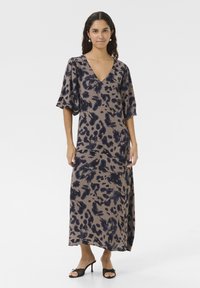 Rochie maxi bej cu un model abstract în nuanțe de albastru închis. Prezintă un decolteu în V și mâneci scurte tip puff, fiind realizată dintr-un material ușor.
