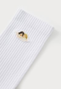 White ribbed socks featuring an embroidered design of two stylized figures on a cloud, with accents in black and yellow.