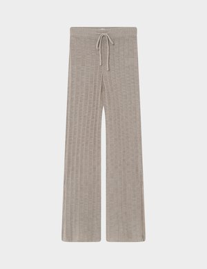 Pantalones anchos de punto beige con canalé vertical y cintura con cordón, colocados planos sobre un fondo claro.