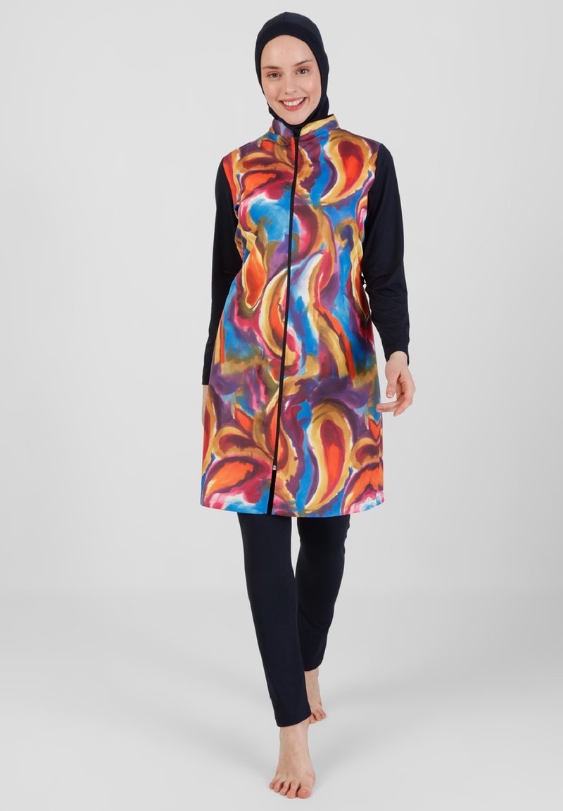 Vestido de baño abstracto y colorido con un alto cuello, cremallera frontal y largas mangas negras, combinado con leggings negros. Textura suave.