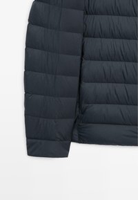 Marineblauer Puffer-Jacke mit einem gesteppten Design, das eine glatte Textur und horizontale Paneele aufweist, mit einem Reißverschluss an der Seite.