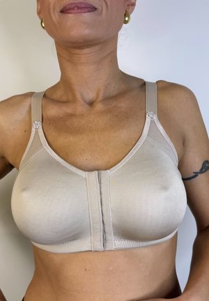 Sujeción beige con cierre frontal, fabricado en tejido suave, que cuenta con tirantes anchos, sutiles acentos florales y un diseño de copas sin costuras.