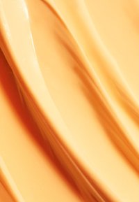 Peach-colored, smooth-textured product with glossy, wavy surface. Subtle variations in shade create a gentle, undulating appearance.