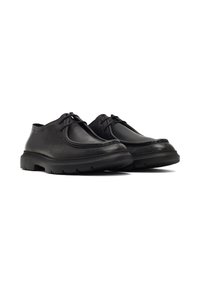 Scarpe in pelle nera con design arrotondato, caratterizzate da una suola testurizzata e una chiusura semplice con lacci. Suola in gomma resistente per maggiore aderenza.