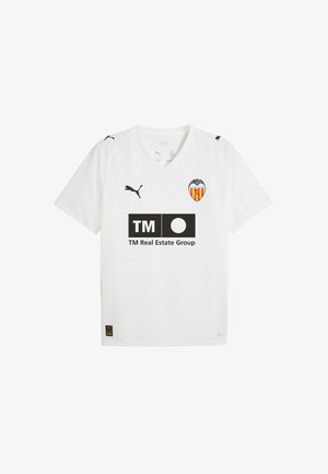 Maillot de football blanc avec un motif texturé, col en V, logo Puma sur les manches, écusson de l'équipe et un logo de sponsor noir sur le devant.