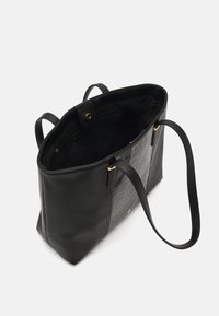 Geantă tote din piele neagră, cu un side texturat cu model de crocodil. Dispune de accesorii cu finisaj auriu, două mânere și un închizător cu buton.