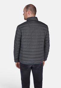Polstret grå jakke med høj krave, quilted design og en glat tekstur. Synlig syning og en subtil kantaccent.