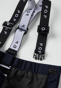 Marineblauwe stoffen bretels met zwart-witte afgedrukte banden met het "P.O.P." logo, verstelbare hardware en veilige clips. Zachte binnenvoering zichtbaar.