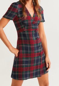 Kleid in rot, grün und marineblau mit Karomuster, kurzen Ärmeln, einem V-Ausschnitt und Knöpfen entlang der Vorderseite. Strukturierter Stoff, ausgestellte Silhouette und Seitentaschen.