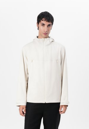 Ljusbeige zip-up jacka med huva, som har två framfickor och en slät yta. Långa ärmar med justerbara manschetter.