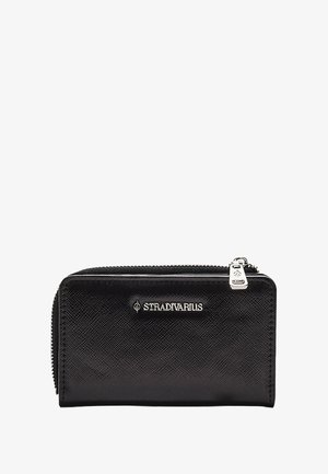 Schwarzes Reißverschluss-Portemonnaie aus strukturiertem synthetischem Material mit silberfarbenen Komponenten und einem auf der Vorderseite prägten Logo. Kompakte rechteckige Form.