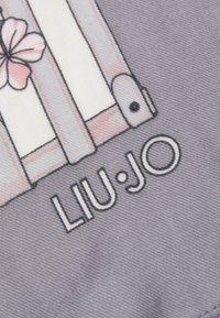 Material purpuriu cu un design ce include o poartă și o floare, cu numele brandului "LIU·JO" afișat proeminent cu litere mari.