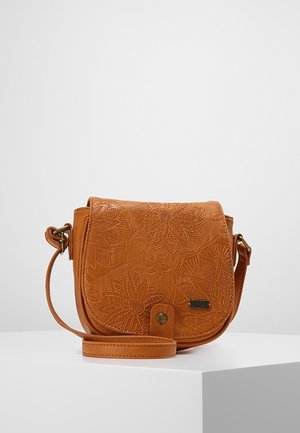 Petit sac bandoulière en cuir beige avec motifs floraux en relief, fermeture à rabat et bandoulière réglable, posé sur une surface blanche.