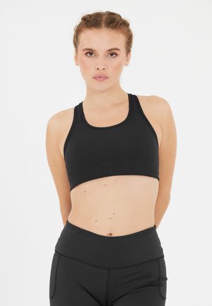 Schwarzer Sport-BH mit einem schlanken Design, rundem Ausschnitt und breiten Trägern. Aus dehnbarem, atmungsaktivem Stoff gefertigt. Reicht bis zur Mitte des Bauches.