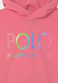 Sudadera rosa con el texto multicolor "POLO RALPH LAUREN" en la parte frontal y una capucha doblada en la parte superior central.