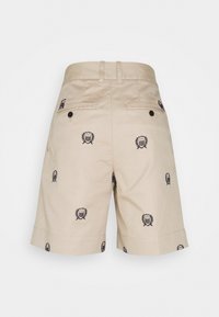 Béžové kraťasy vyrobené z bavlny, s námořnickými vyšitými emblémy, dvěma zadními kapsami a skládacím lemem.