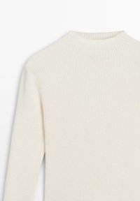 Top a maniche lunghe con coste, colore crema, design a collo alto. Texture morbida con righe verticali, leggero e sagomato.