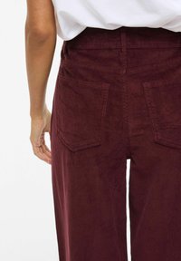 Bordeaux corduroy broek met een rechte snit, voorzien van twee achterzakken, een gestructureerd oppervlak en een hoog tailleontwerp.